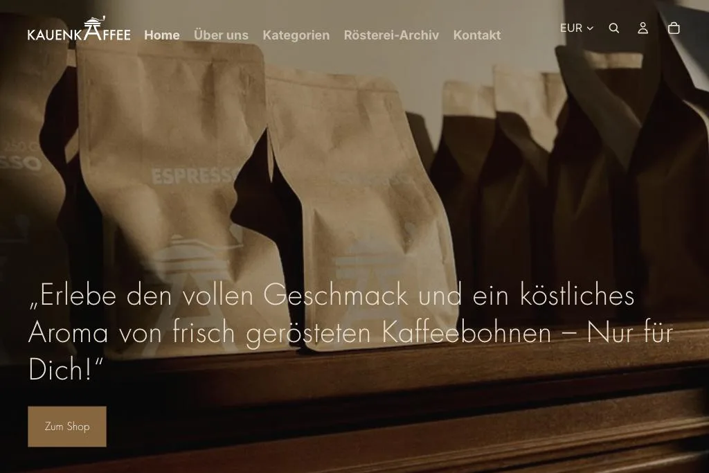 Startseite von kauenkaffee.de mit Kaffeebohnen-Verpackungen im Regal und der Schlagzeile des Shops darüber.